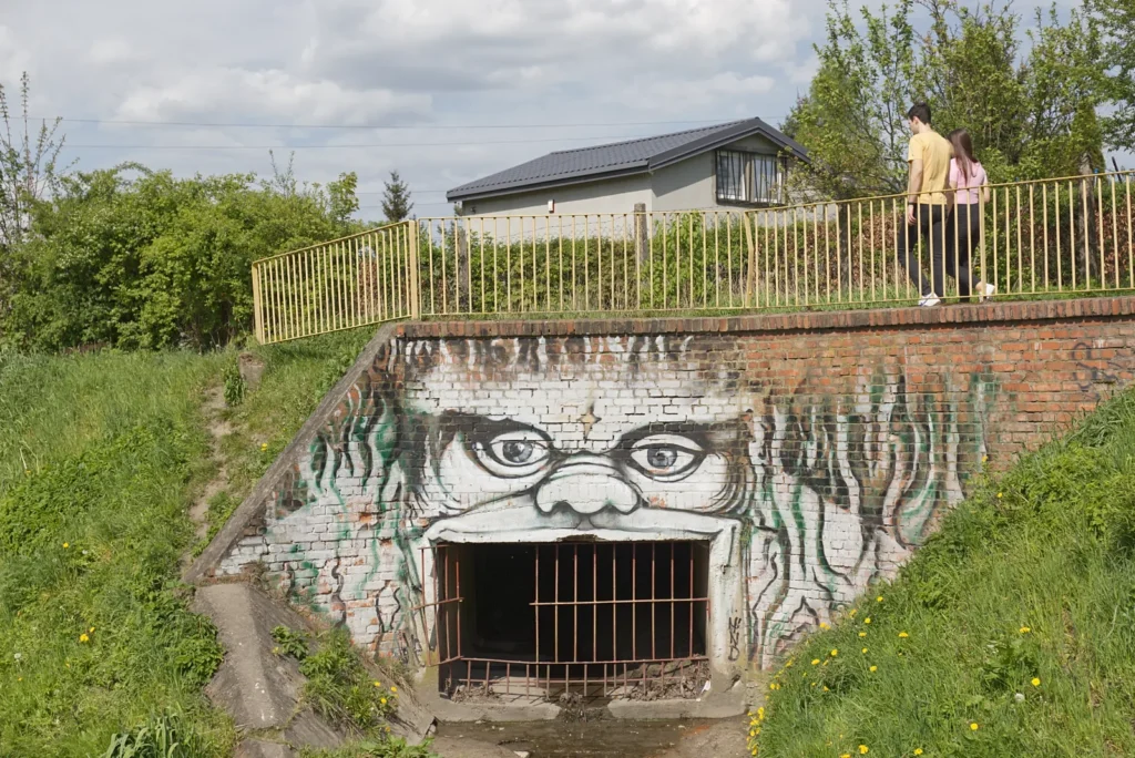 Mural i wejście do miejskich kanałów.