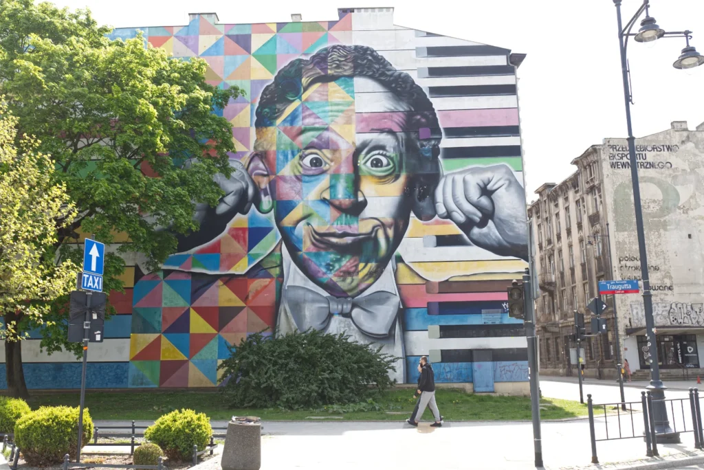 Zabawny mural na ścianie, czyli głowa mężczyzny trzymającego się uszy i robiącego minę